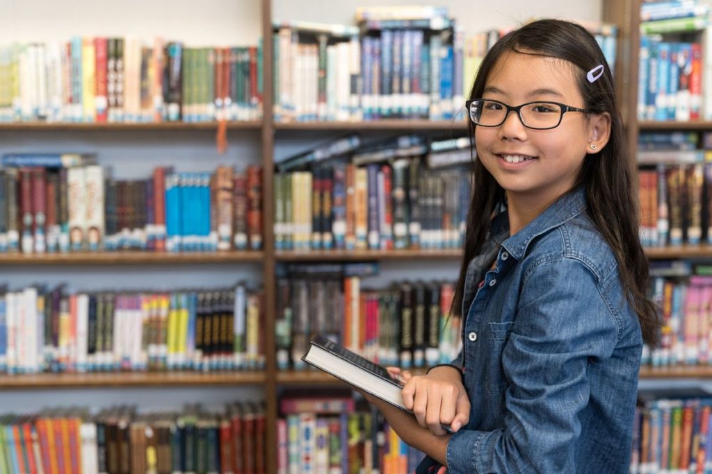 asian teenage girl with eyeglasses in school libra WZMUB compressor